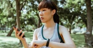concentrated-young-asian-woman-using-smartphone-in-park