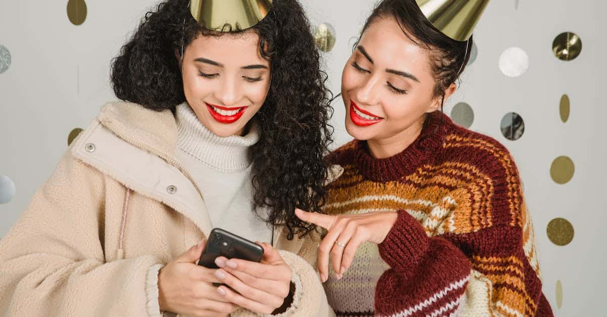 content-female-friends-wearing-party-hats-surfing-cellphone-and-standing-on-white-background-with-ha