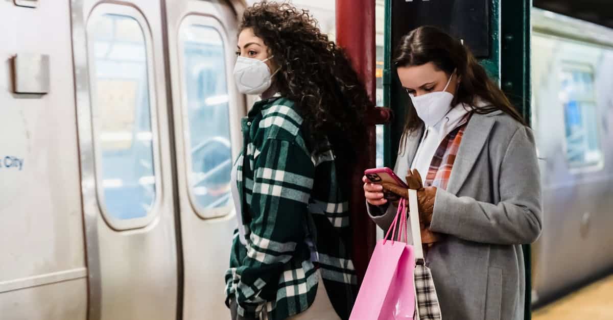 girlfriends-in-masks-using-cellphone-in-underground-station-near-train