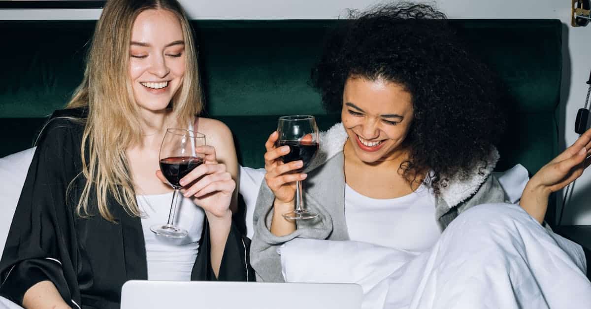 two-young-women-having-fun-while-looking-at-a-laptop